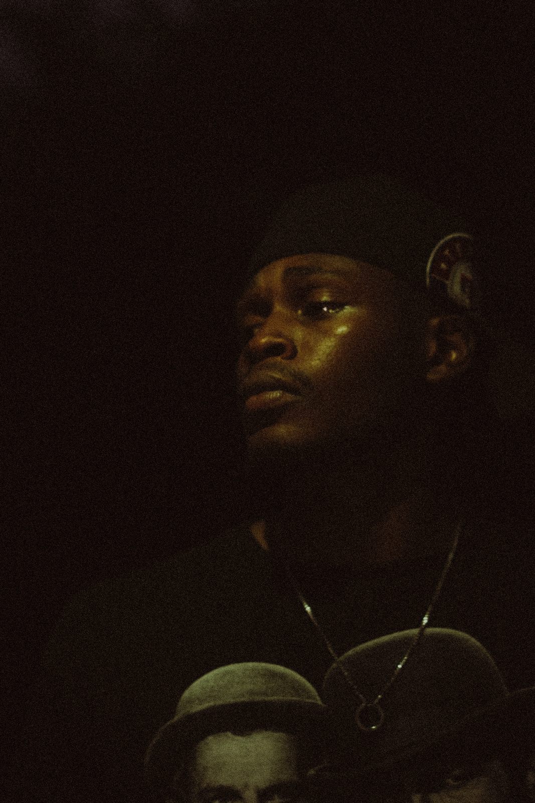 Portrait of KTG, moody low light, gold chain visible